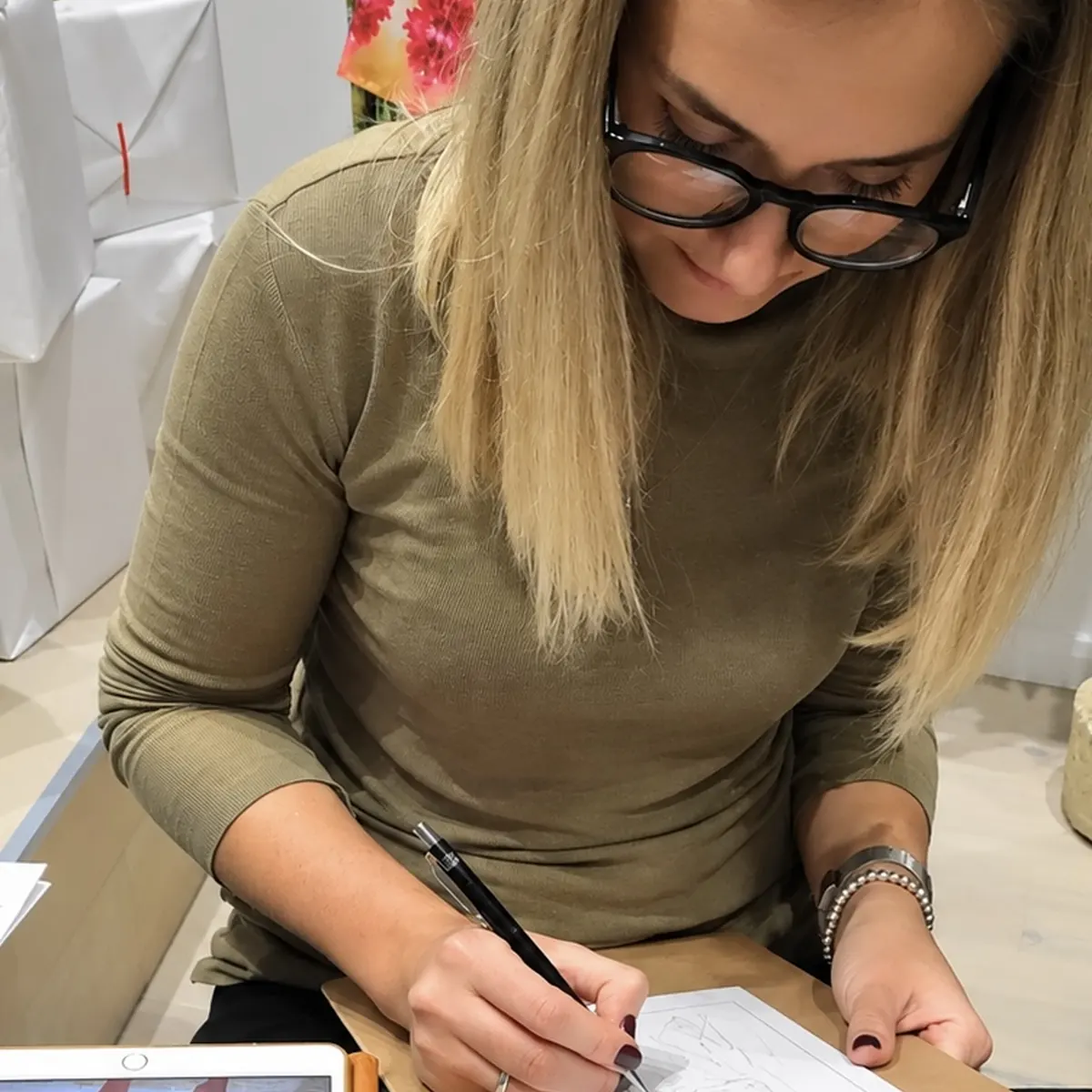 Jenny Nazarova sketching guests at a boutique event