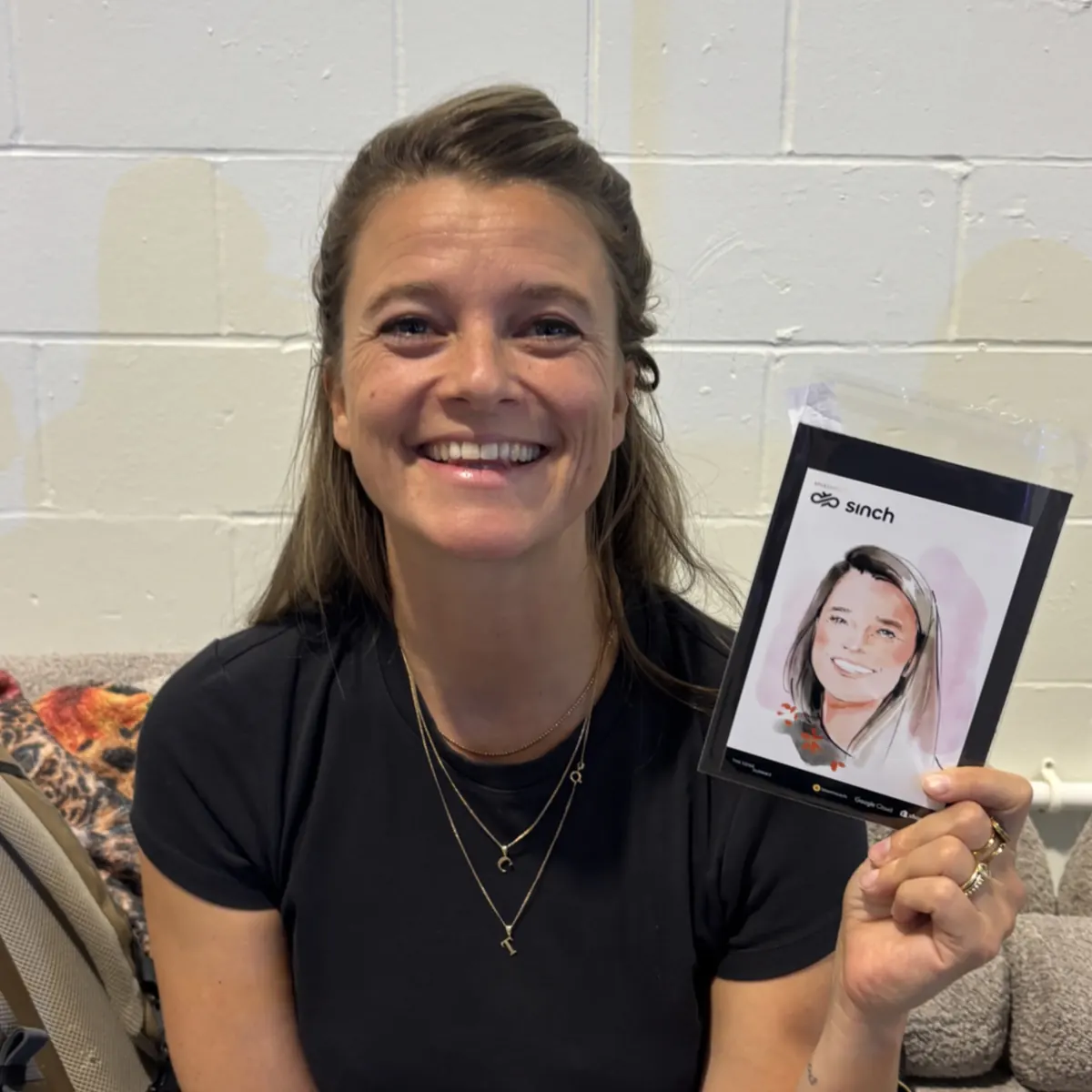 Smiling guest holding her portrait at a corporate event