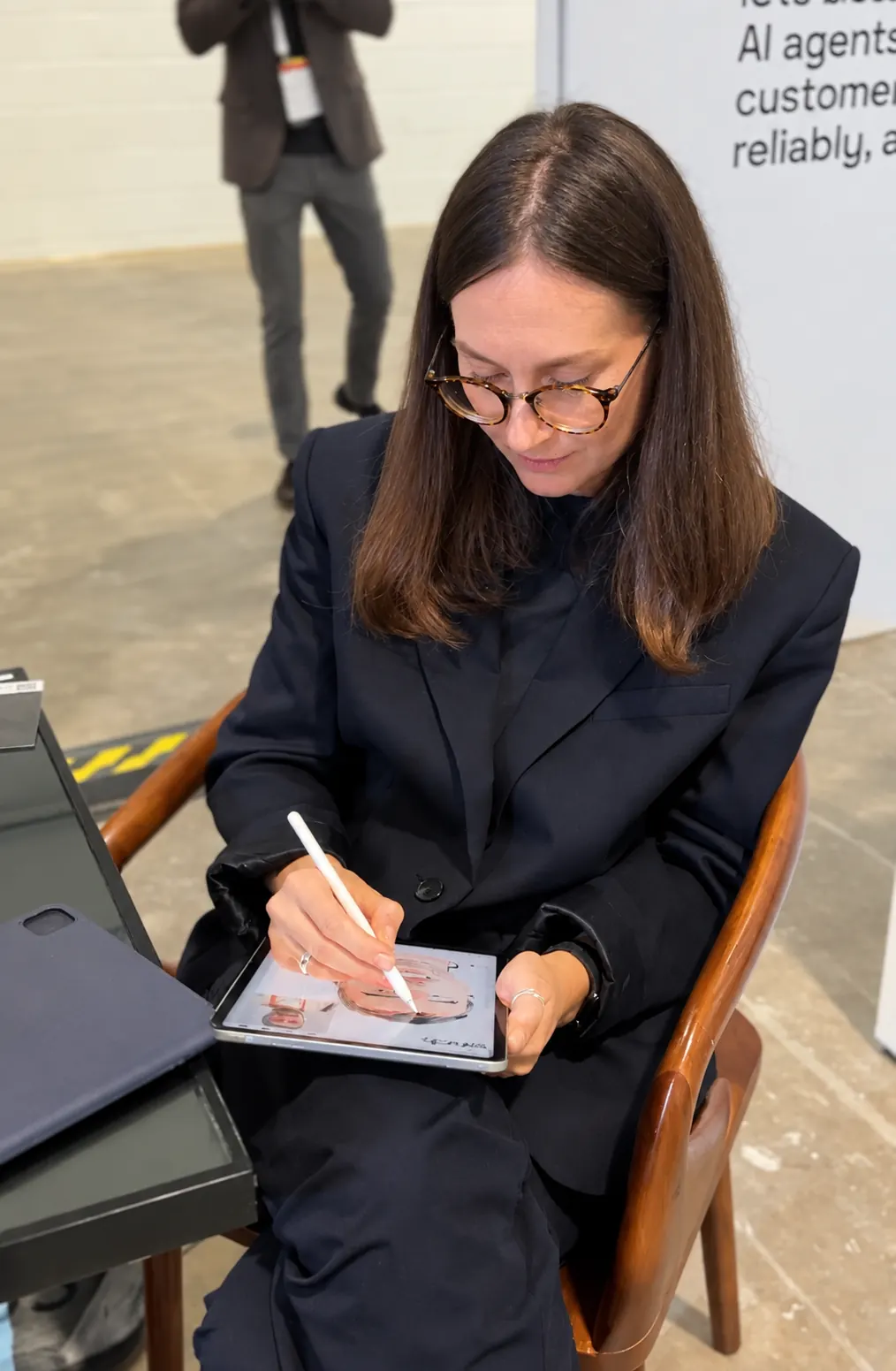 Jenny Nazarova drawing a guest portrait on iPad at an event